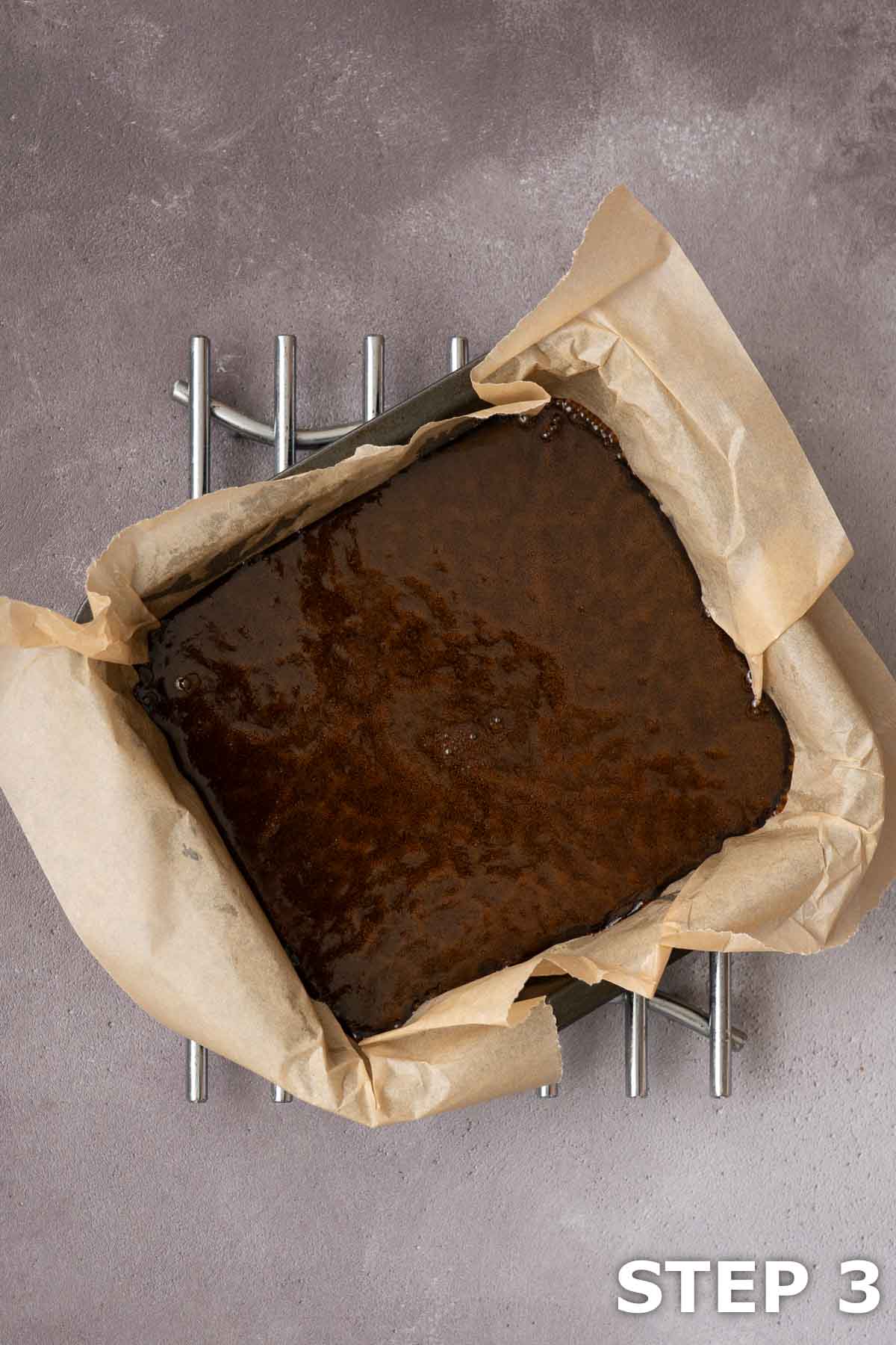 Treacle toffee poured into a baking tin lined with baking parchment.