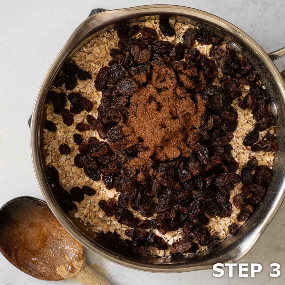 Rolled oats, raisins and mixed spice in a saucepan.