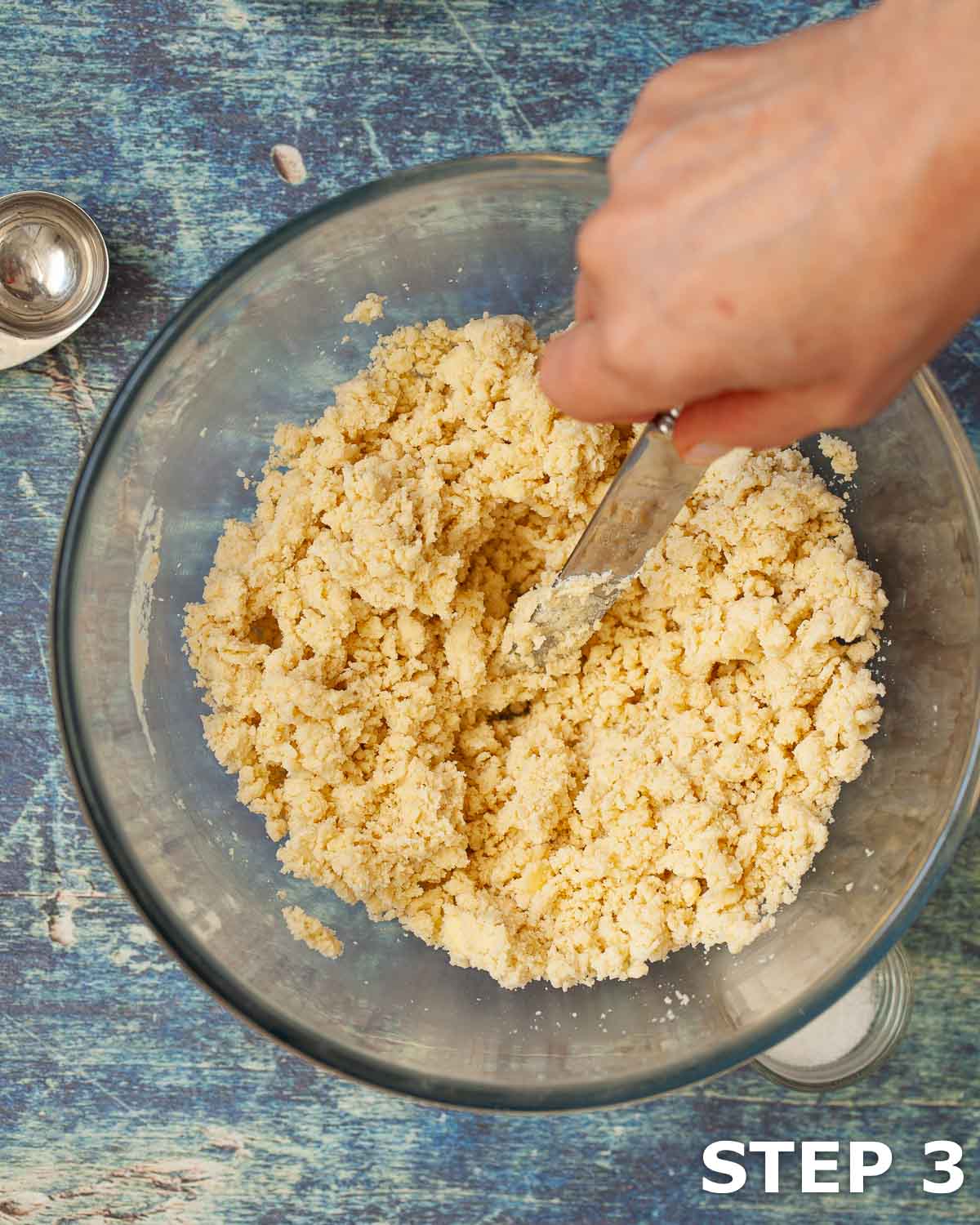 Person mixing water into flour and butter to make pastry dough.