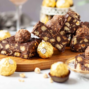 Chocolate tiffin slices on a board with chocolate hazelnut balls on the top.