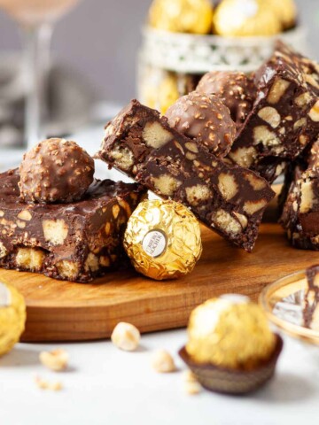 Chocolate tiffin slices on a board with chocolate hazelnut balls on the top.