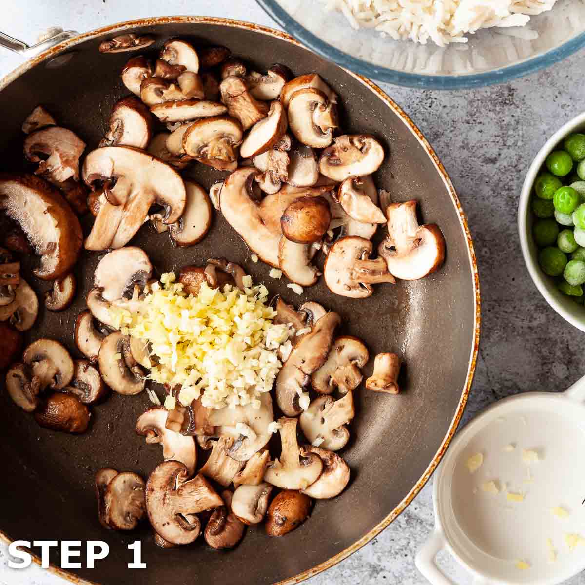 Sliced mushrooms in a frying pan with garlic and ginger.