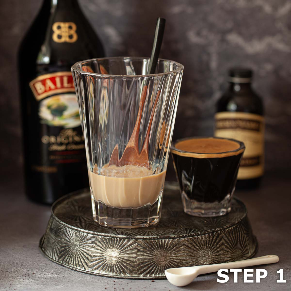 Baileys Irish cream in a heatproof coffee glass with espresso at the side.