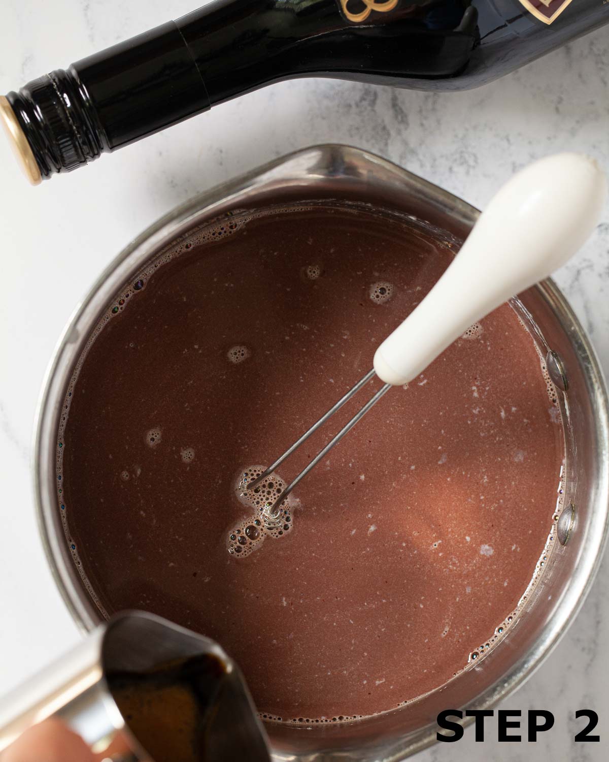 Espresso coffee being added to a pan of milk and melted chocolate.