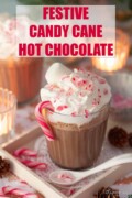 Labelled candy cane hot cocoa topped with whipped cream, crushed candy cane and marshmallow.