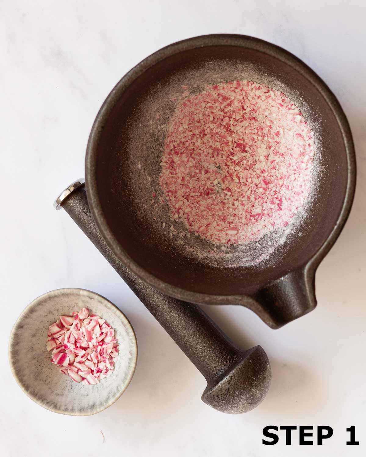 Candy canes crushed to chunks and powder in a pestle and mortar.