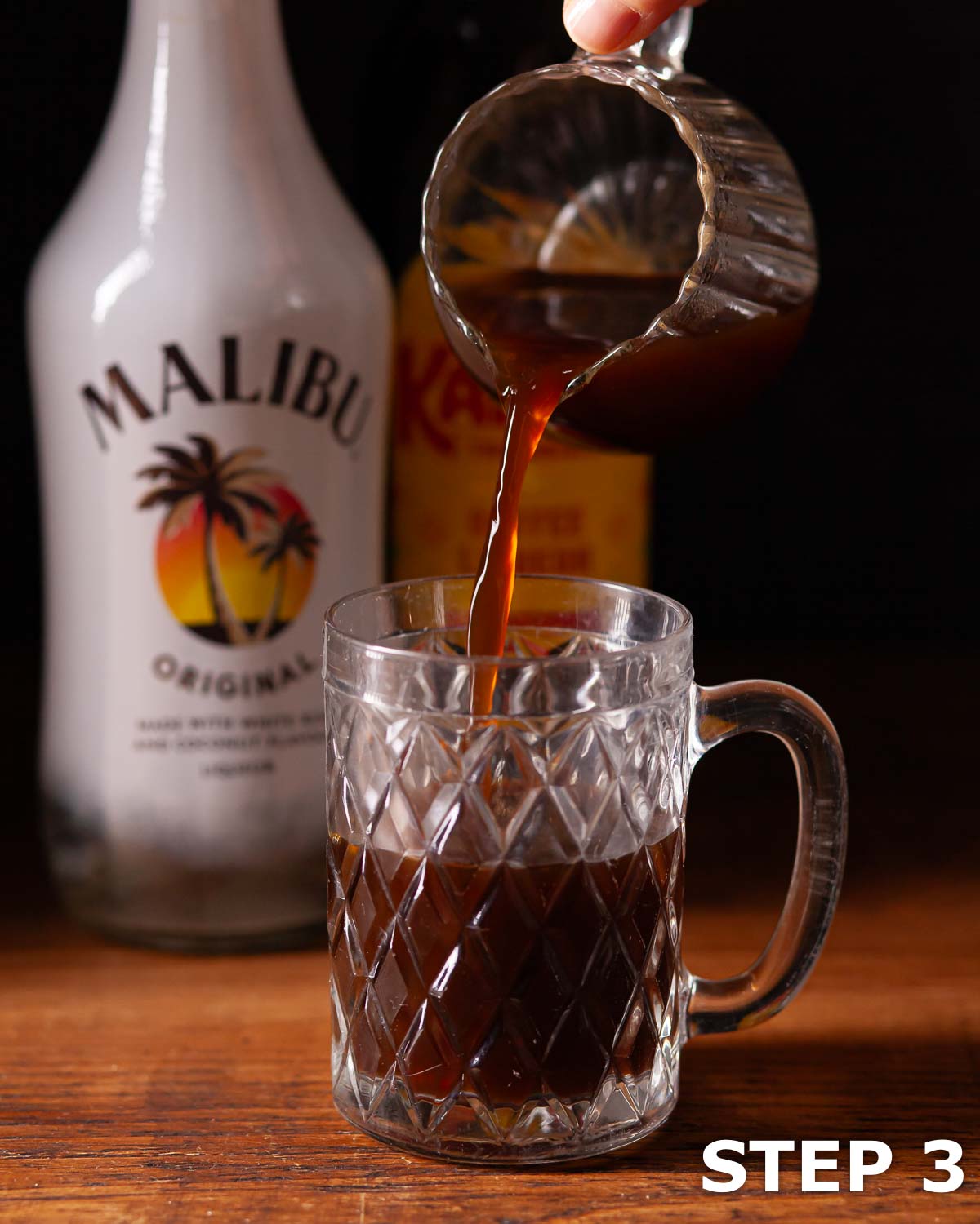 Coffee being poured into a heatproof glass.
