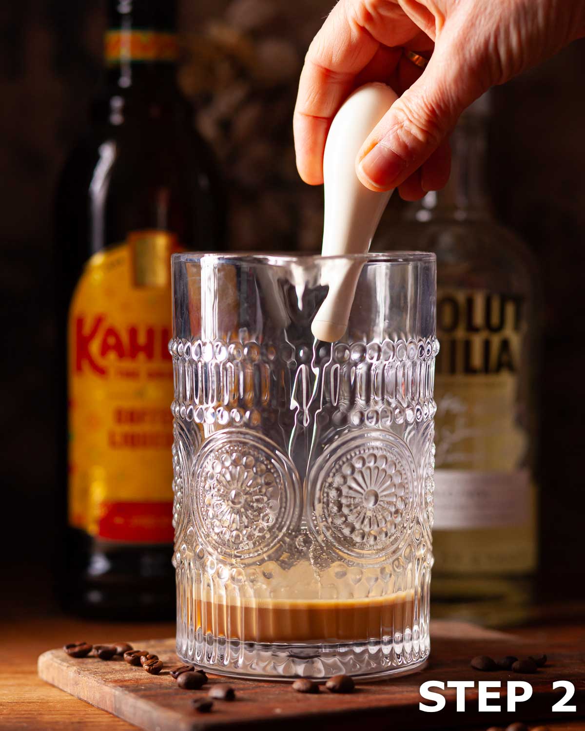 Person stirring espresso and condensed milk when making creamy coffee liqueur.