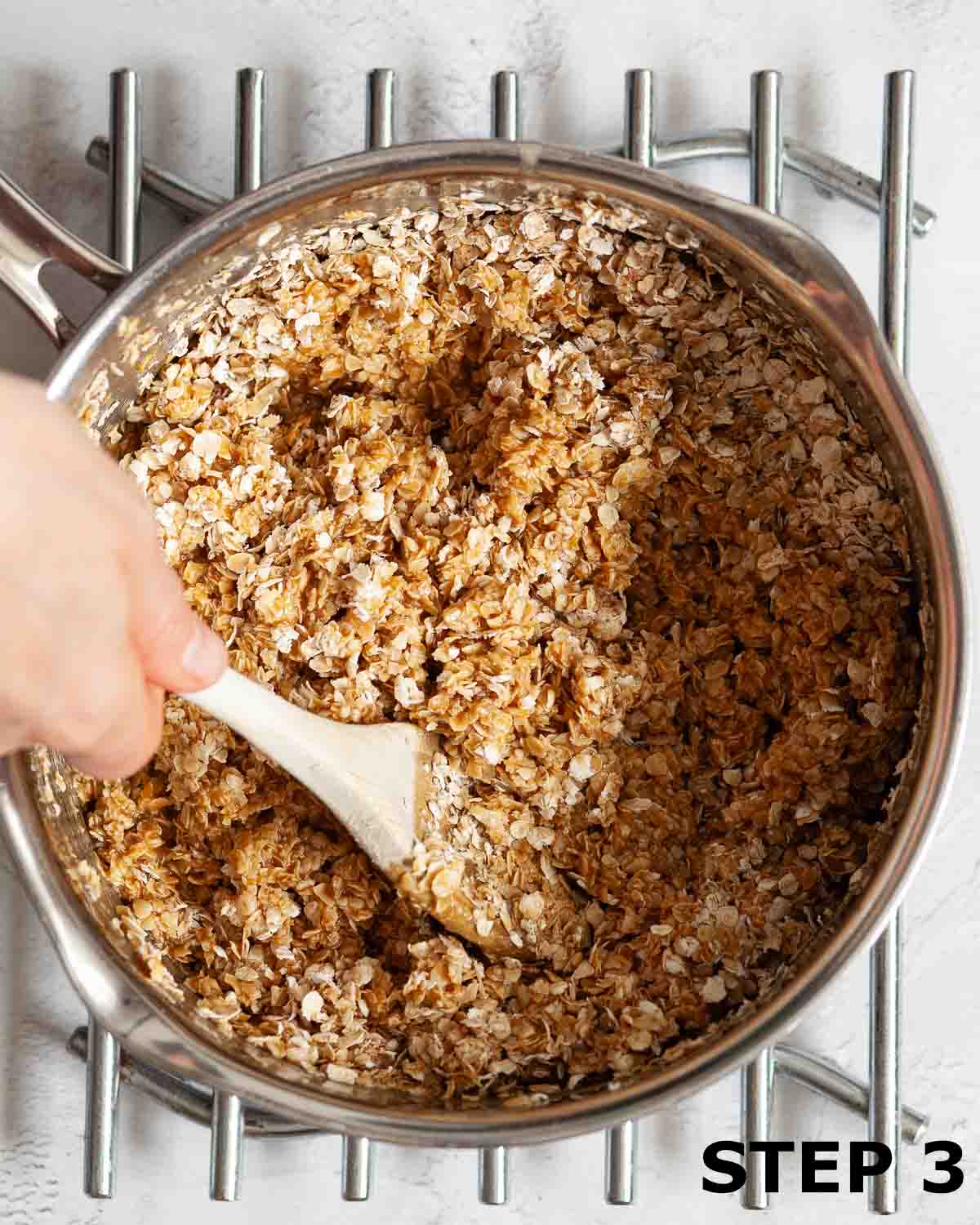 A person stirring oats into liquid ingredients for a flapjack recipe.