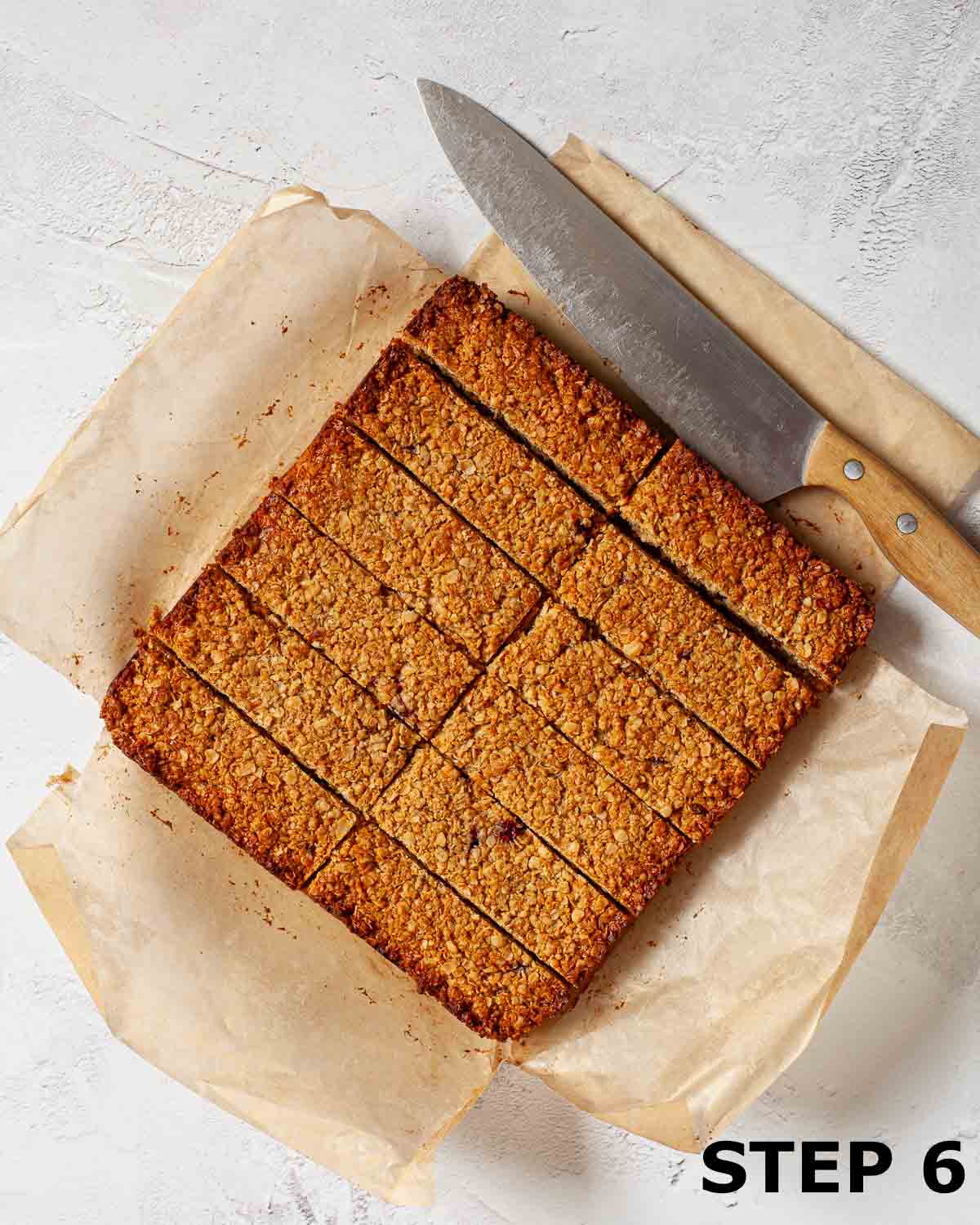 Peanut butter flapjack cut into 12 pieces with the knife alongside.