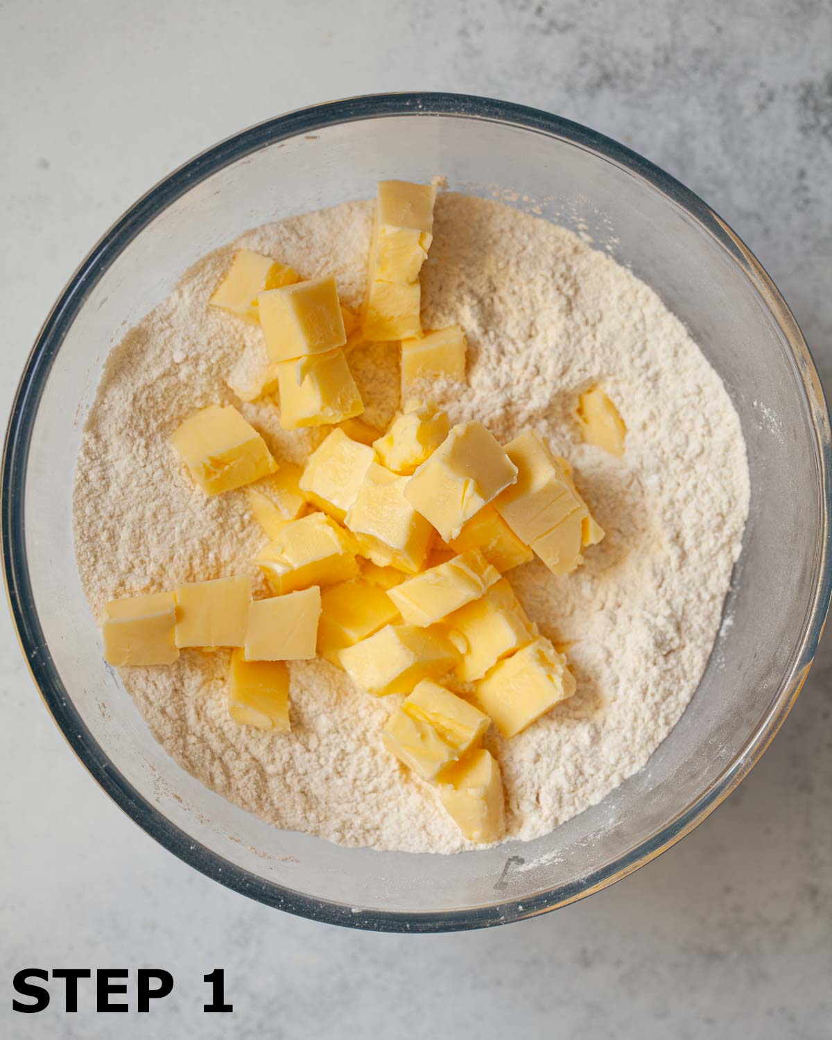 Cubed butter, flour and icing sugar in a bowl ready to make shortcrust pastry.