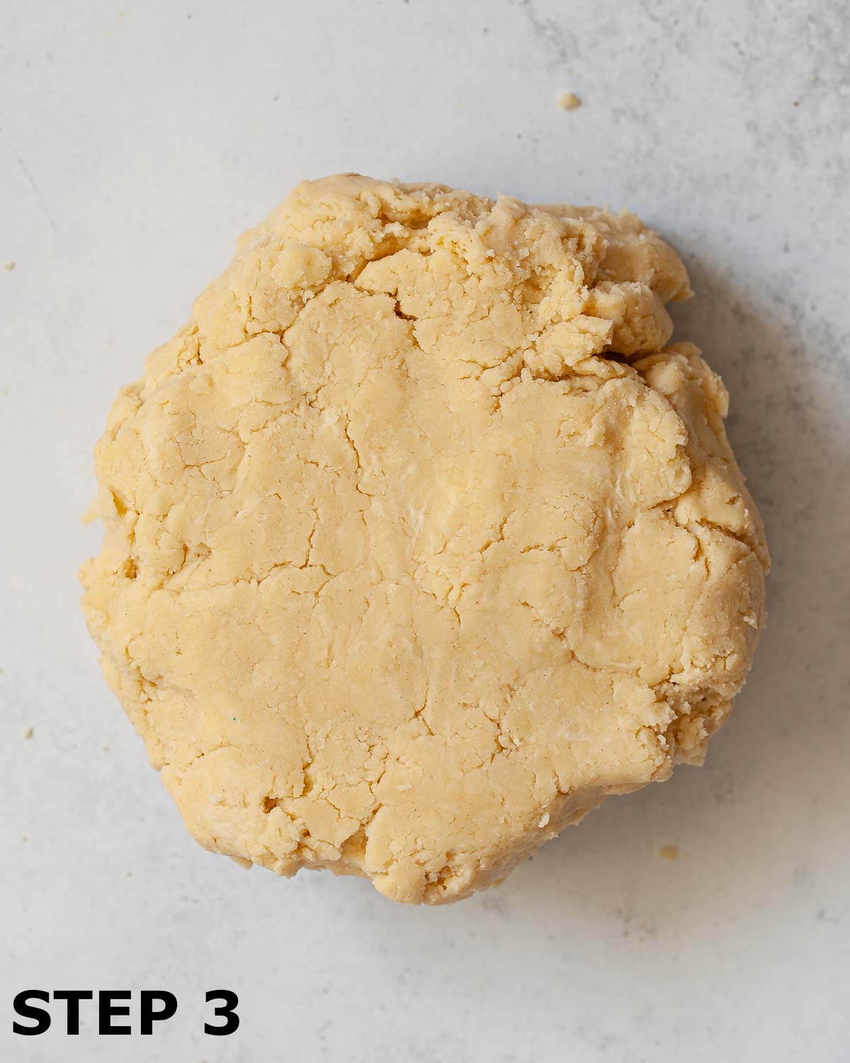 Shortcrust pastry dough shaped into a disc on a worktop.