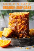 Stacked slices of orange loaf cake with drizzle topping on an upturned metal tin.
