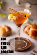 A labelled Easter hot cross bun cocktail with raisin, cinnamon and lemon garnish.