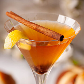 Easter cocktail with raisin, cinnamon and lemon garnish.