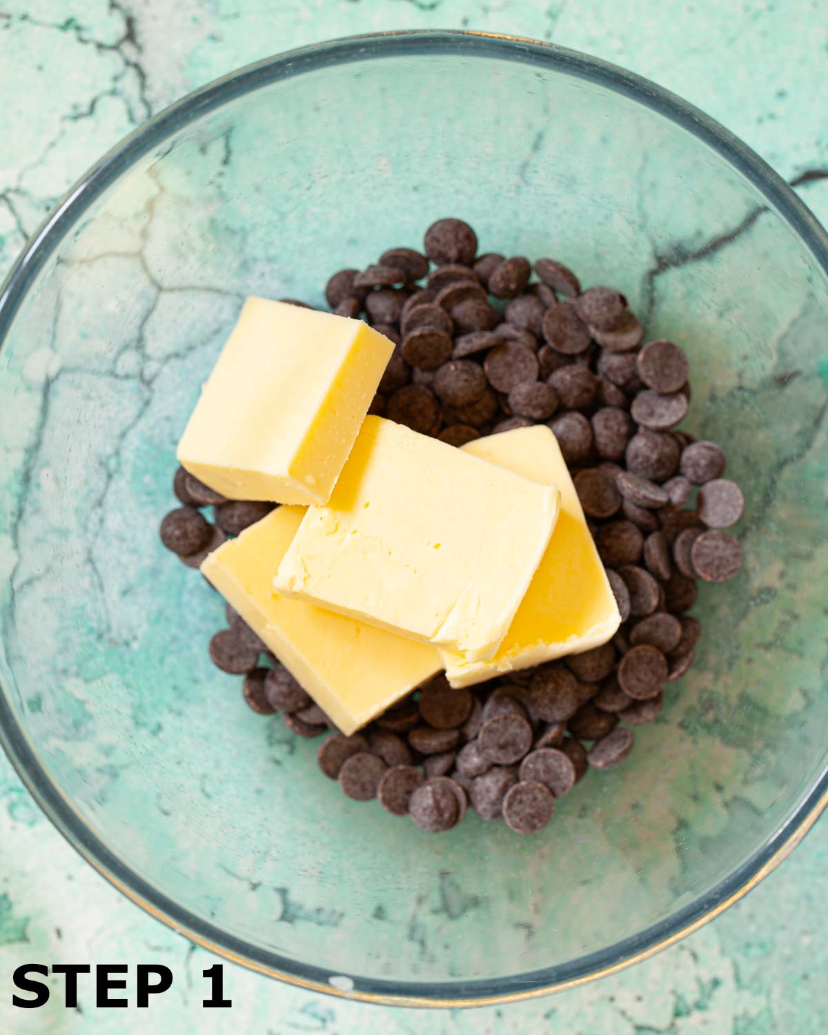 Dark chocolate chips and butter in a glass bowl.