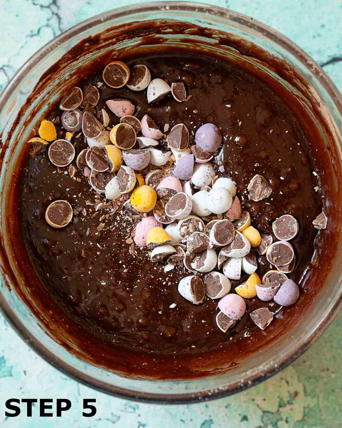 Chopped Mini Eggs chocolates in a bowl of brownie batter.