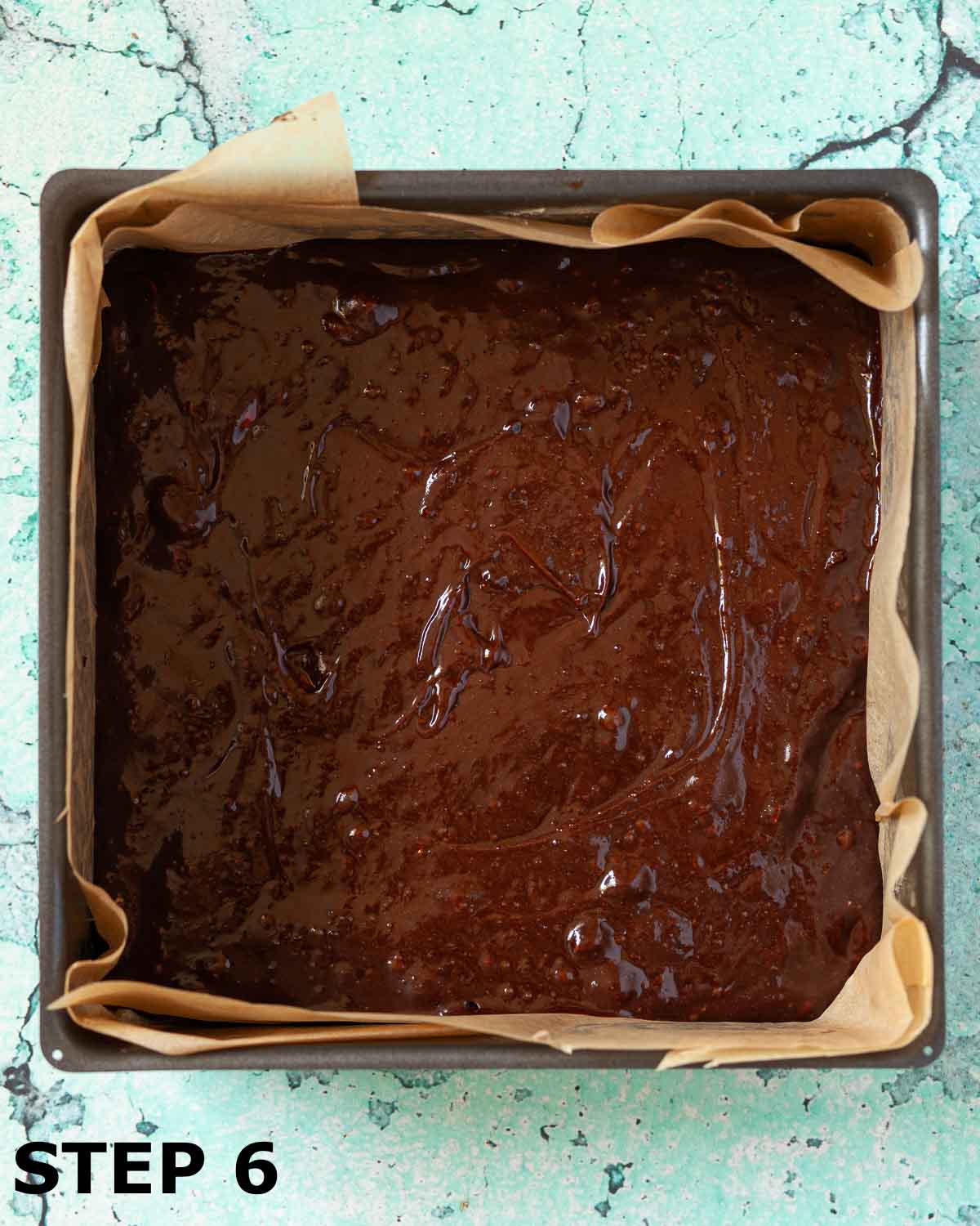 Brownies batter in a lined baking tin.
