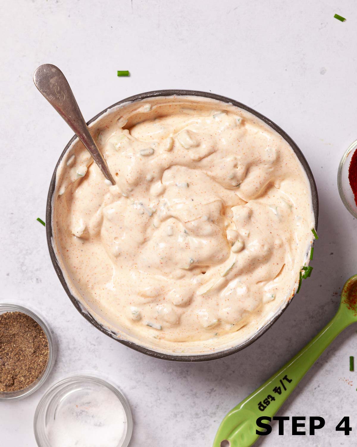 Paprika dip in a micing bowl with a spoon in it.