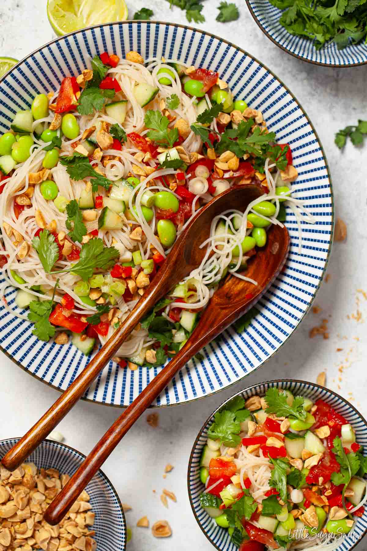 Cucumber tomato noodle salad with edamame beans and red chilli in bowls.