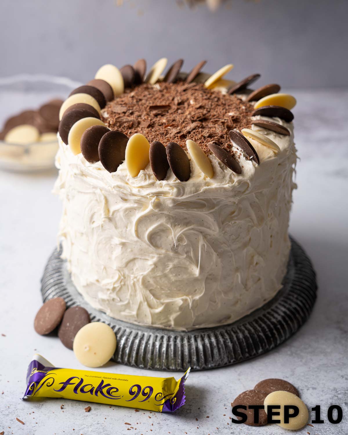 A three layer chocolate cake decorated with flaked chocolate and milk, white & dark chocolate buttons.