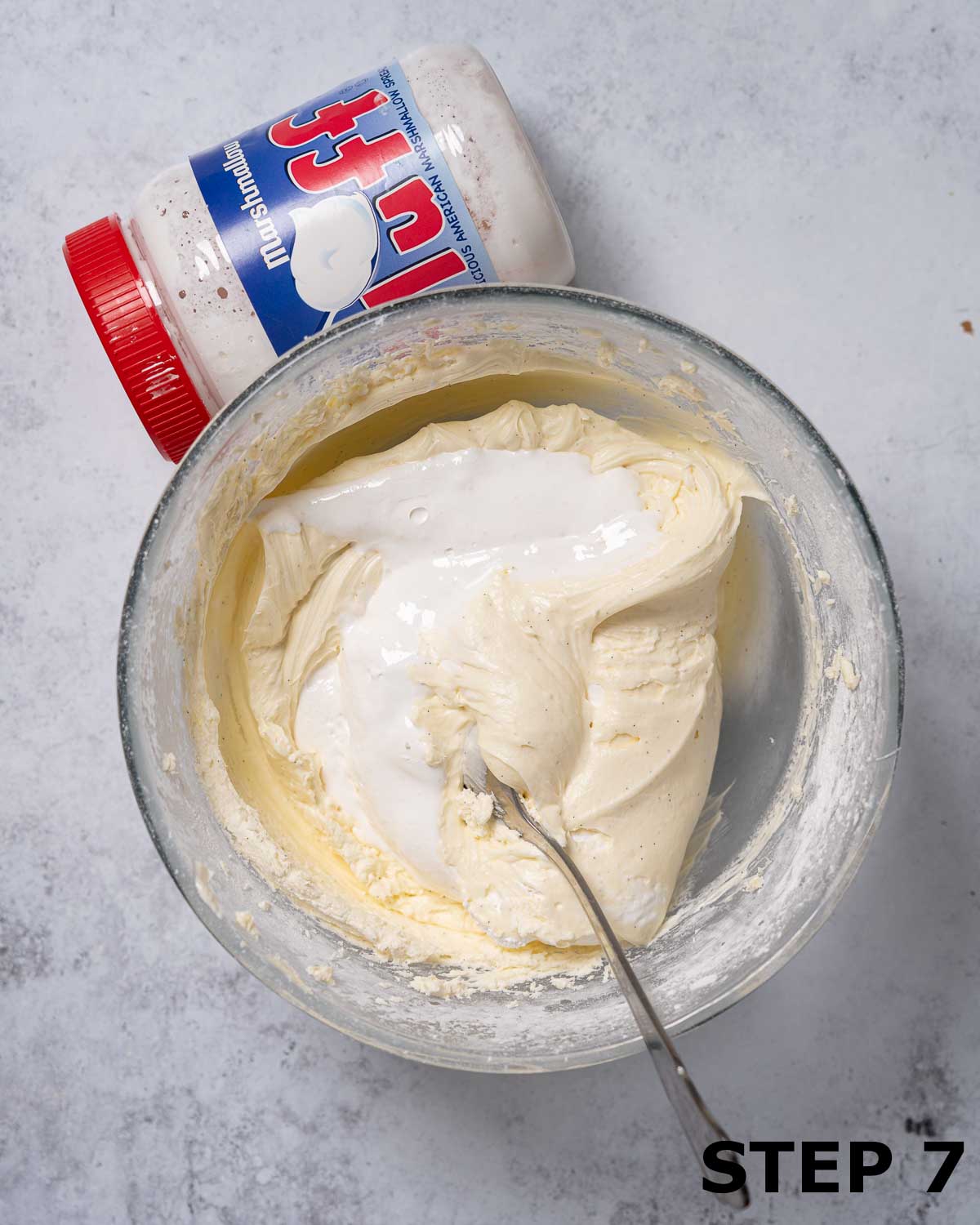 Marshmallow fluff being mixed into cream cheese buttercream.
