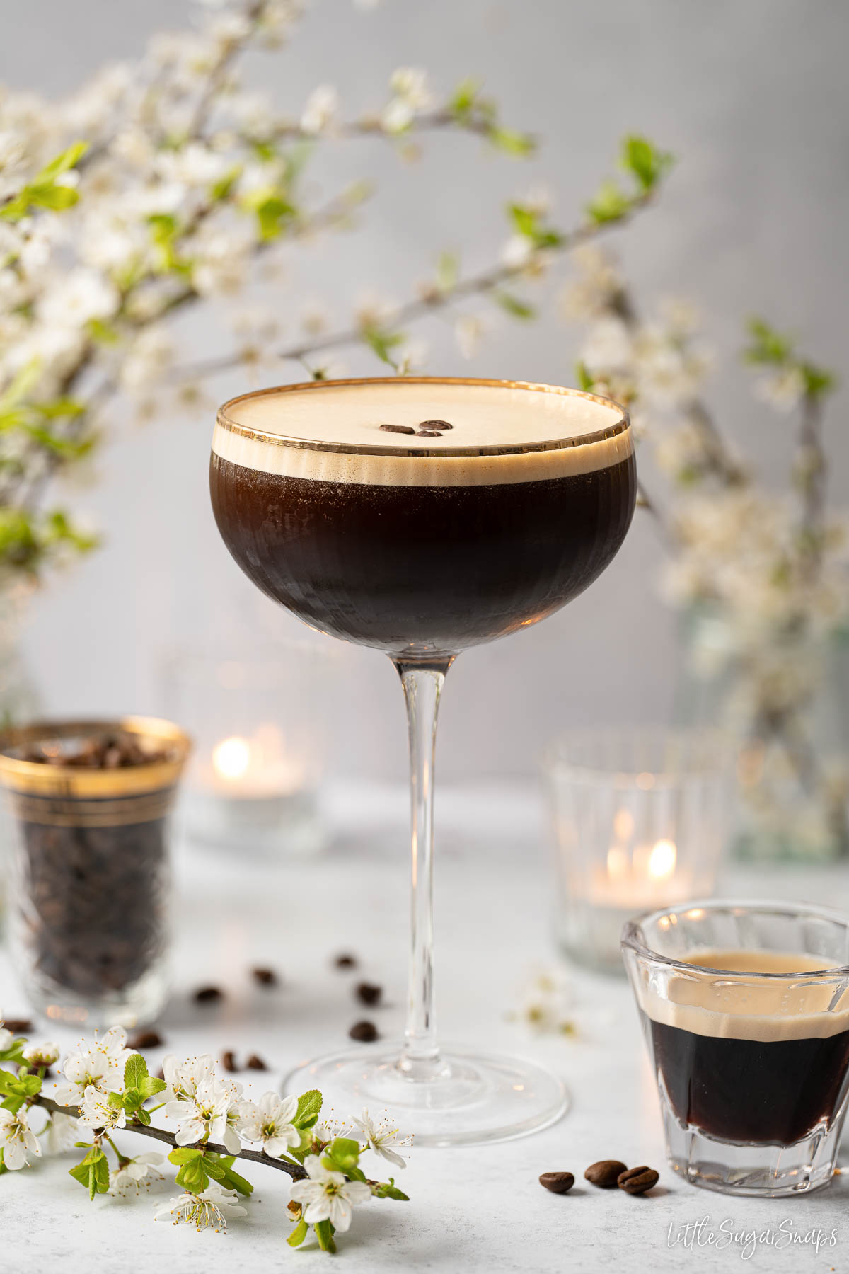 Italian iced coffee in a cocktail glass with frothy top and coffee bean garnish.