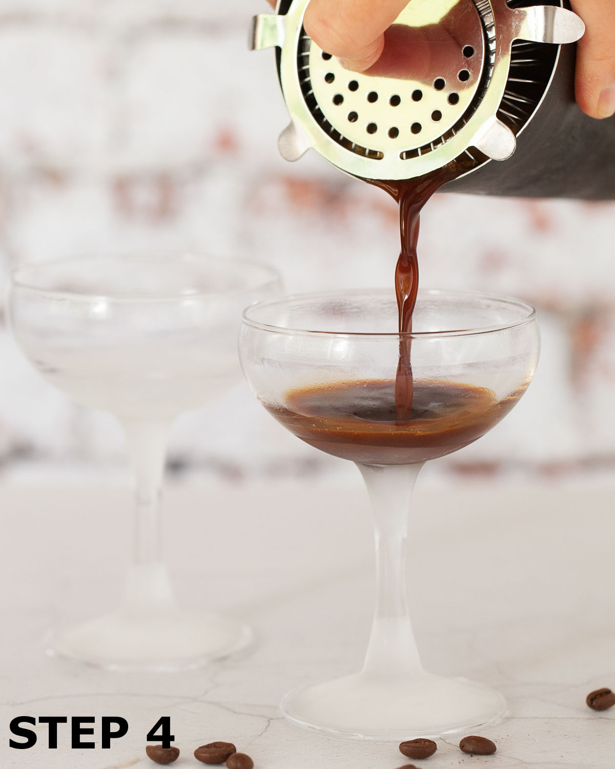An Italian iced espresso coffee being poured into a coupe glass.