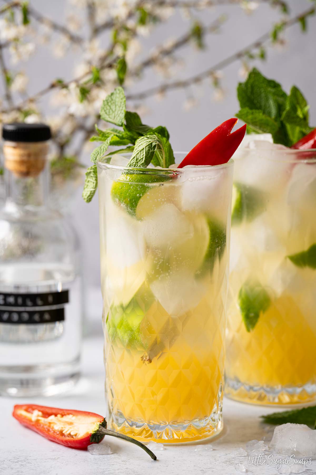 Mango punch cocktails served in highball glasses with mint, lime and chilli garnish.