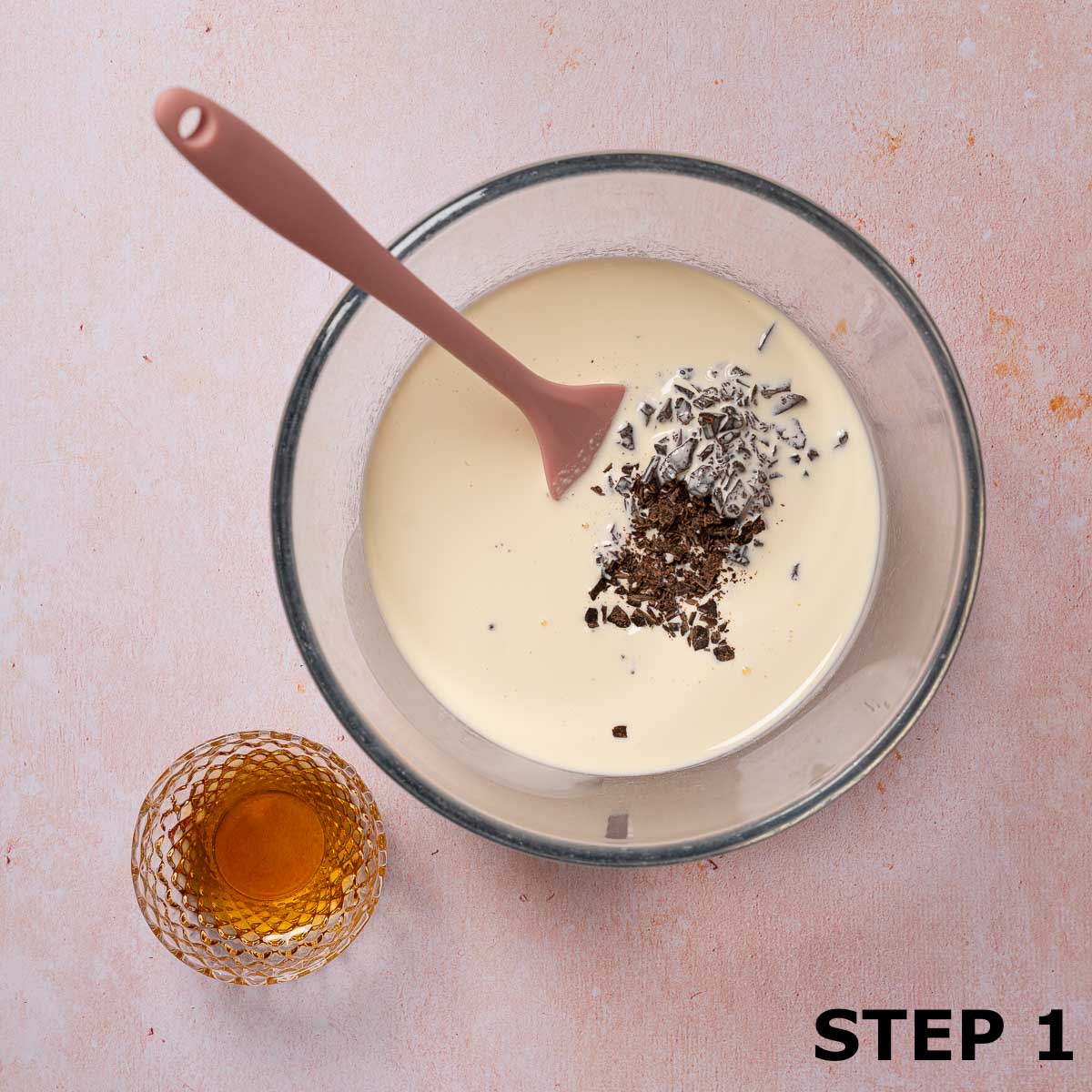 Chopped chocolate in a bowl of cream with maple syrup at the side.
