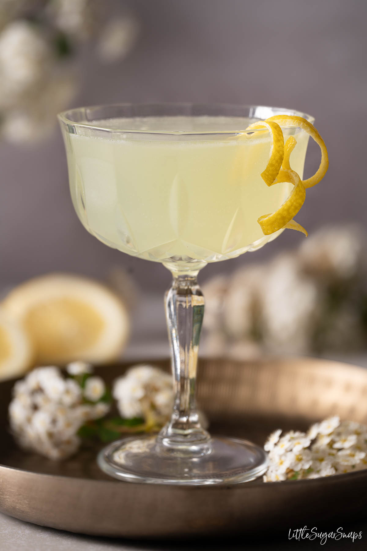 A Spring Feeling gin and chartreuse cocktail garnished with lemon zest spirals.