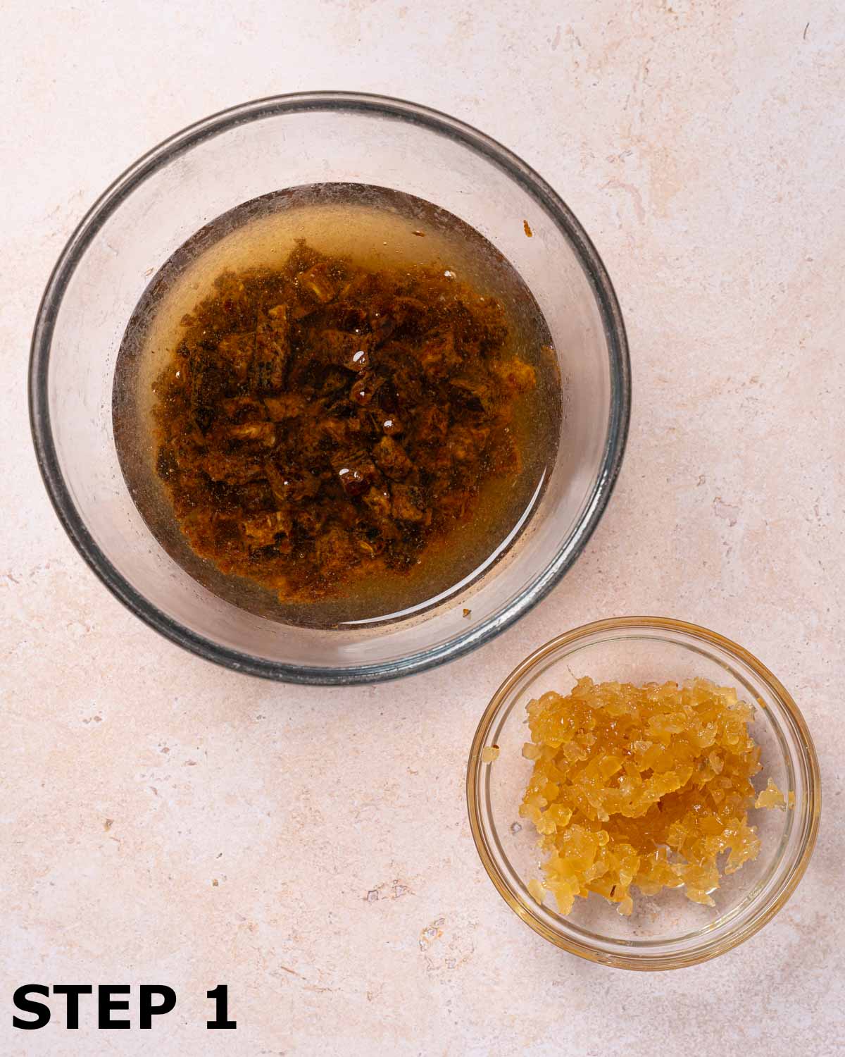 Chopped block dates soaking in a bowl of bicarbonate of soda and hot water with a bowl of minced stem ginger.