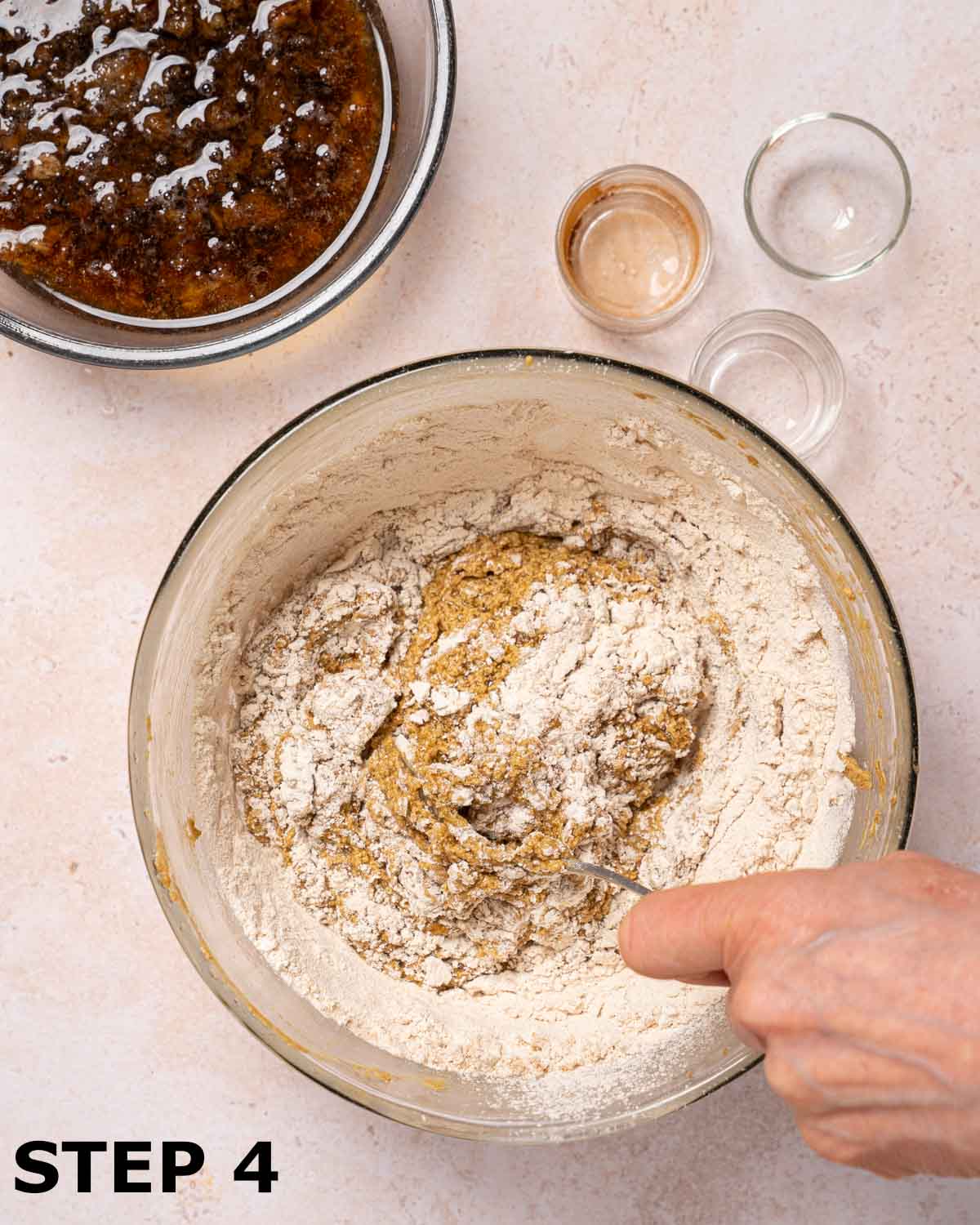 A person folding flour into cake batter.
