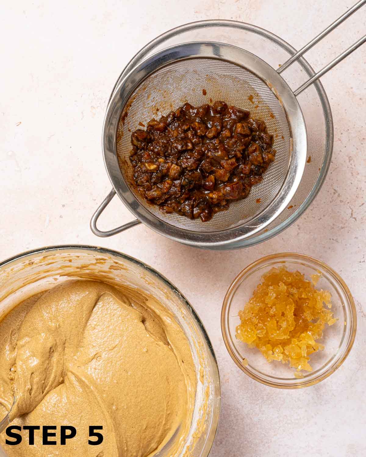 Soaked block dates drained in a sieve with cake batter and chopped stem ginger.
