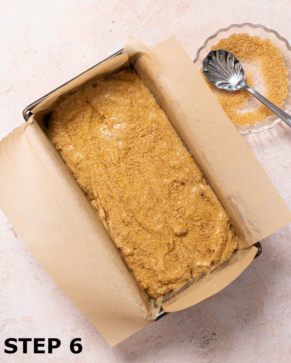 Batter for sticky date loaf in baking tin with Demerara sugar sprinkled over the top.