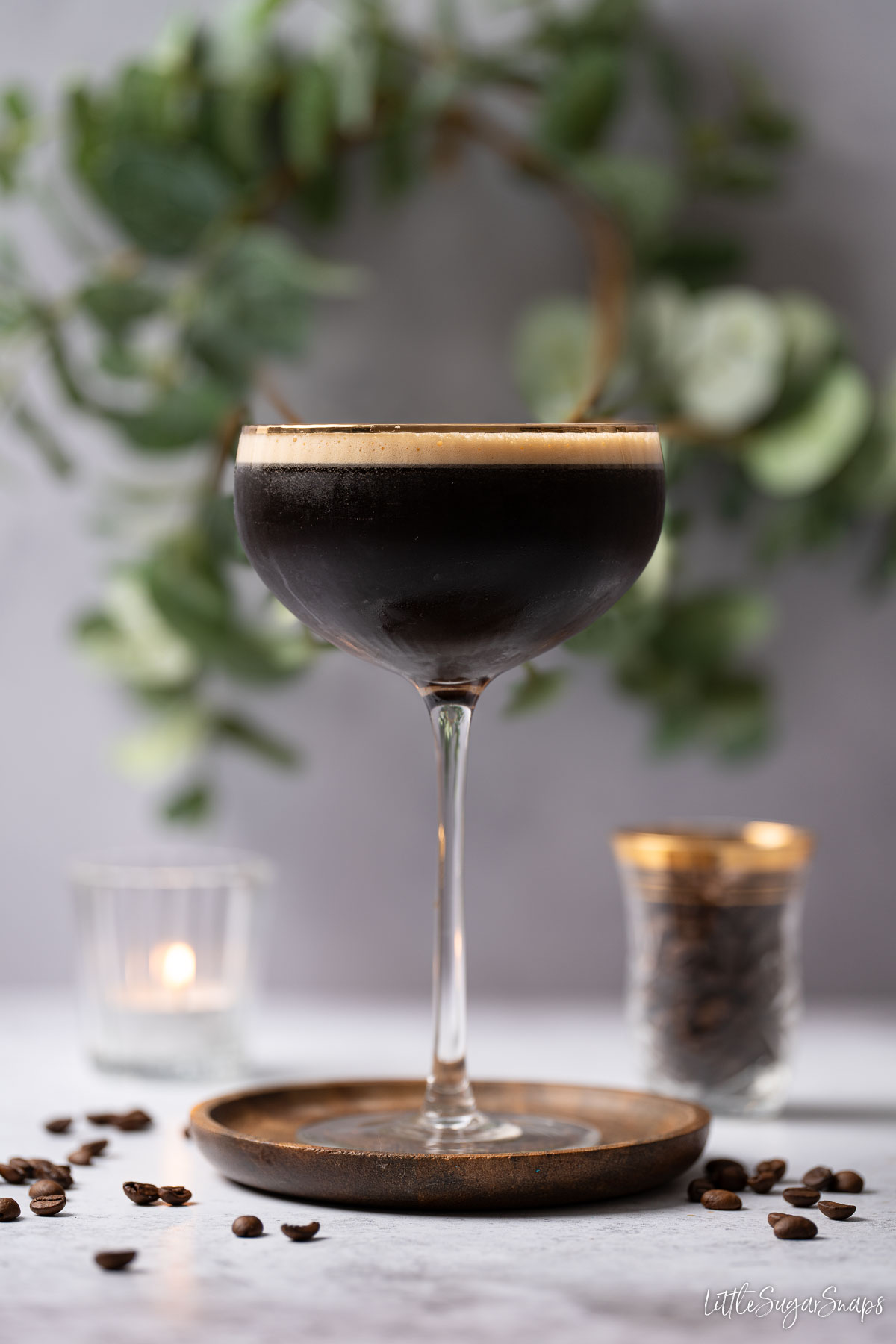 A coffee and tequila cocktail with crema top and coffee bean in the background.
