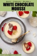 Part-eaten glasses of white chocolate mousse with chocolate and raspberry garnish with text overlay.