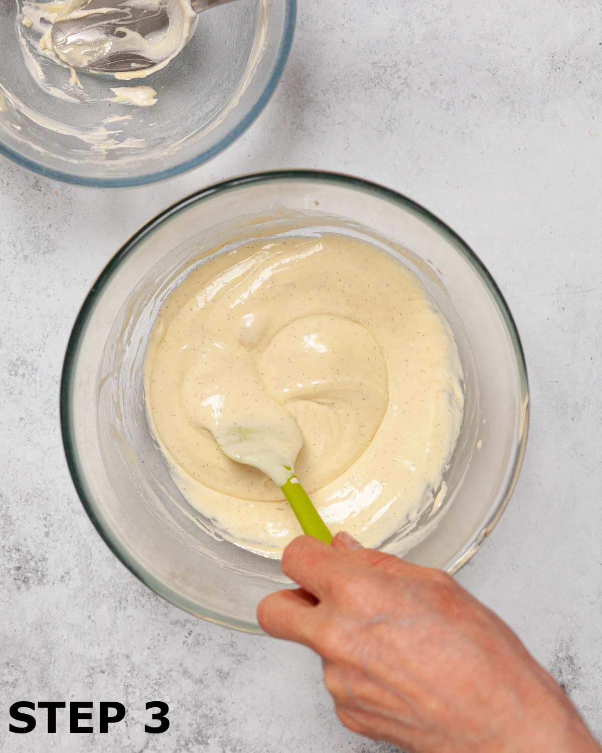 A person folding whipped cream into melted chocolate.