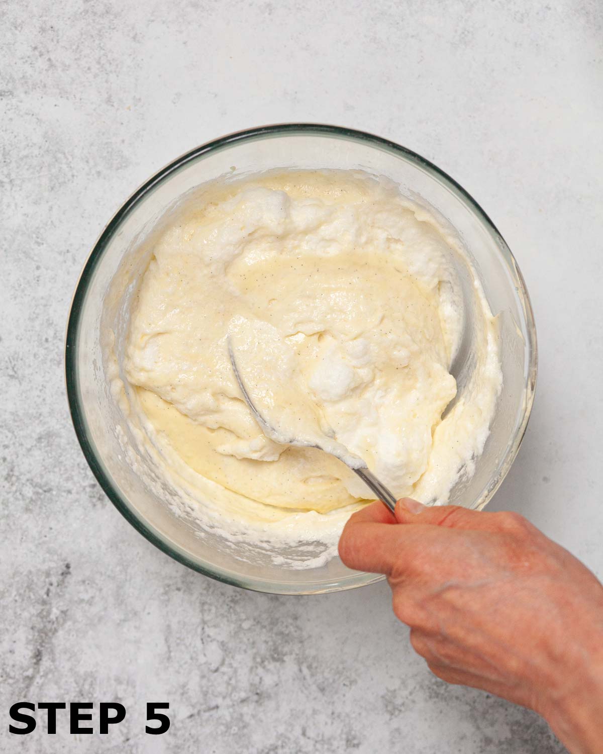A person mixing whipped egg whites into creamy mousse.