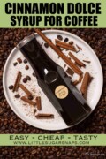 A labelled bottle of cinnamon dolce syrup on a plate with broken cinnamon and coffee beans.