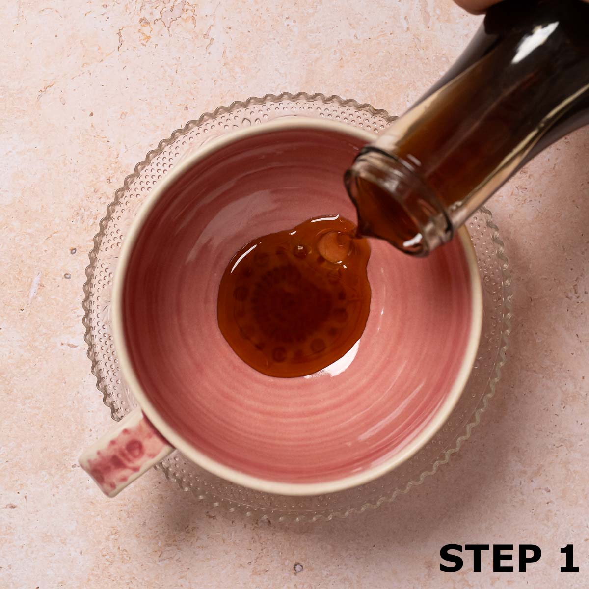 Cinnamon dolce syrup being poured into a pink coffee cup.
