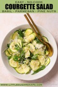 Labelled courgette and basil salad in a bowl with gold cutlery.