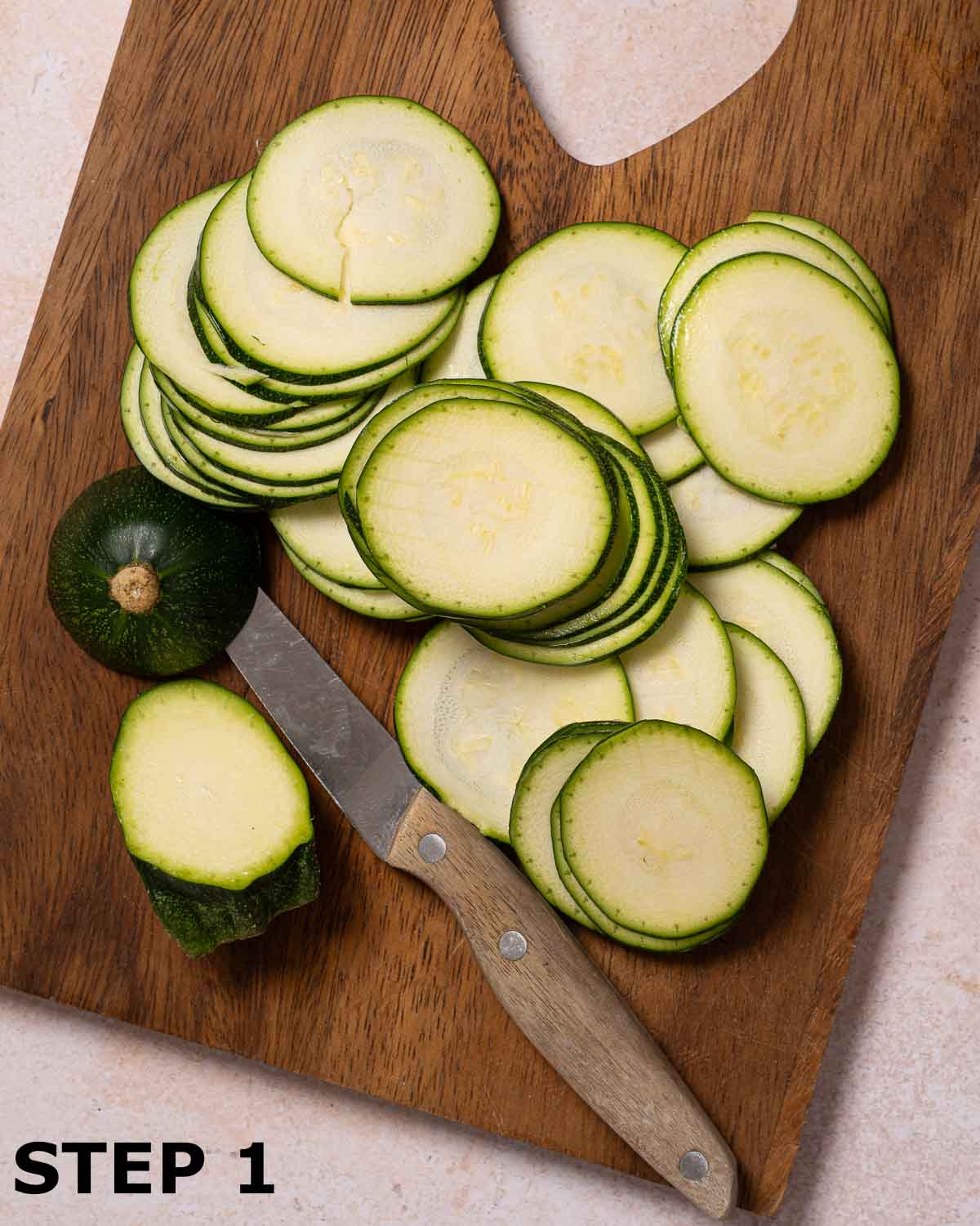 Courgette sliced into rounds on a chopping board.