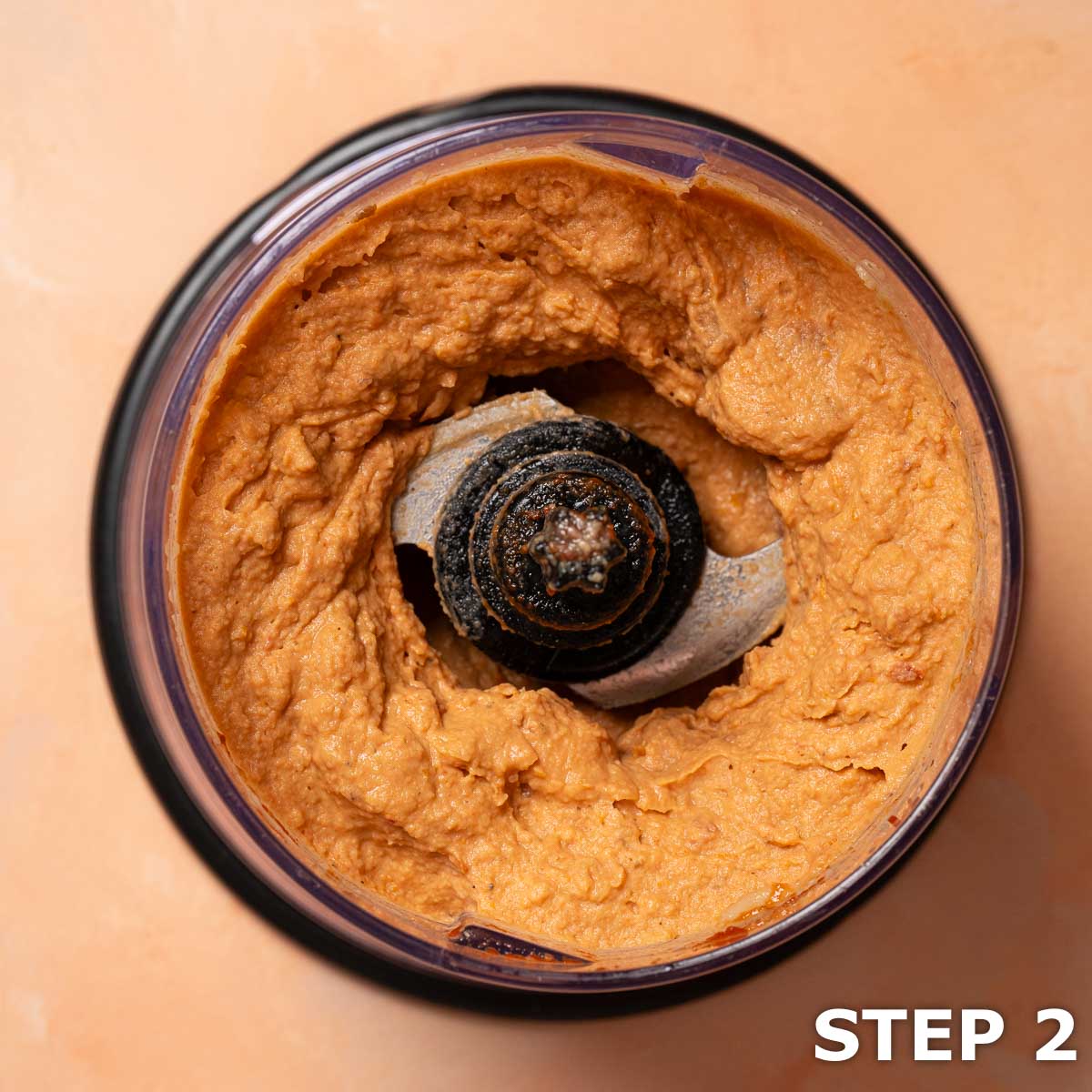 Sun-dried tomato and white bean dip in the bowl of a food processor.