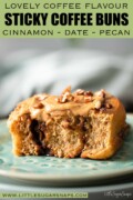 Labelled part eaten cinnamon coffee roll with coffee flavoured glaze and chopped pecan nuts.