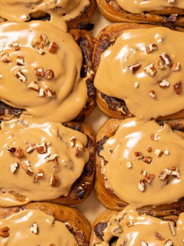 Coffee buns topped with coffee glaze and chopped pecan nuts.