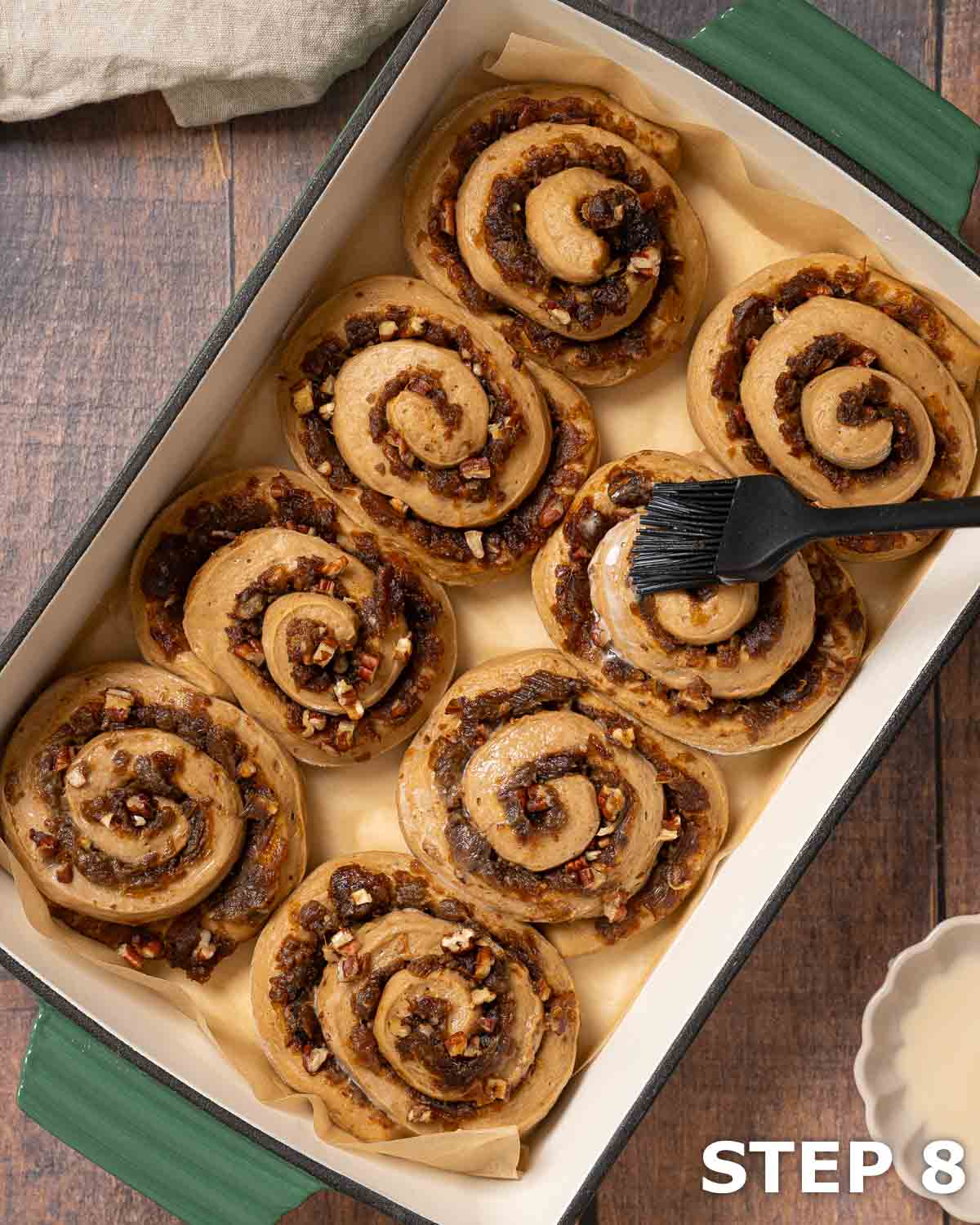 Coffee buns after proving in a baking dish having a milk wash applied.