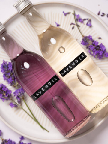 Bottles of labelled lavender simple syrup, one is clear, the other is purple.