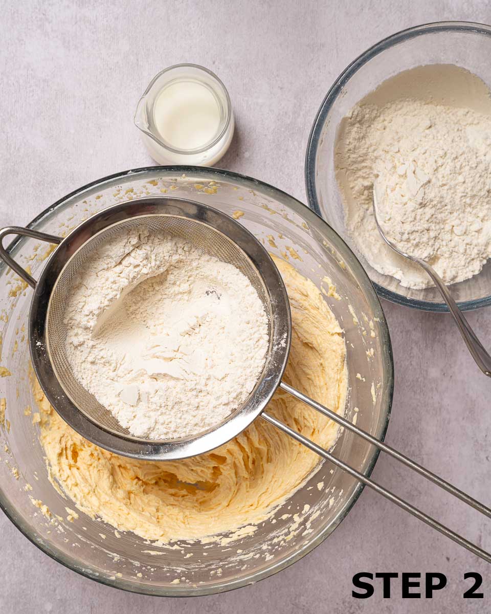 Flour being sieved into cake batter.