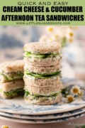 Labelled circular cucumber dill sandwiches on a plate with finger sandwiches behind them.